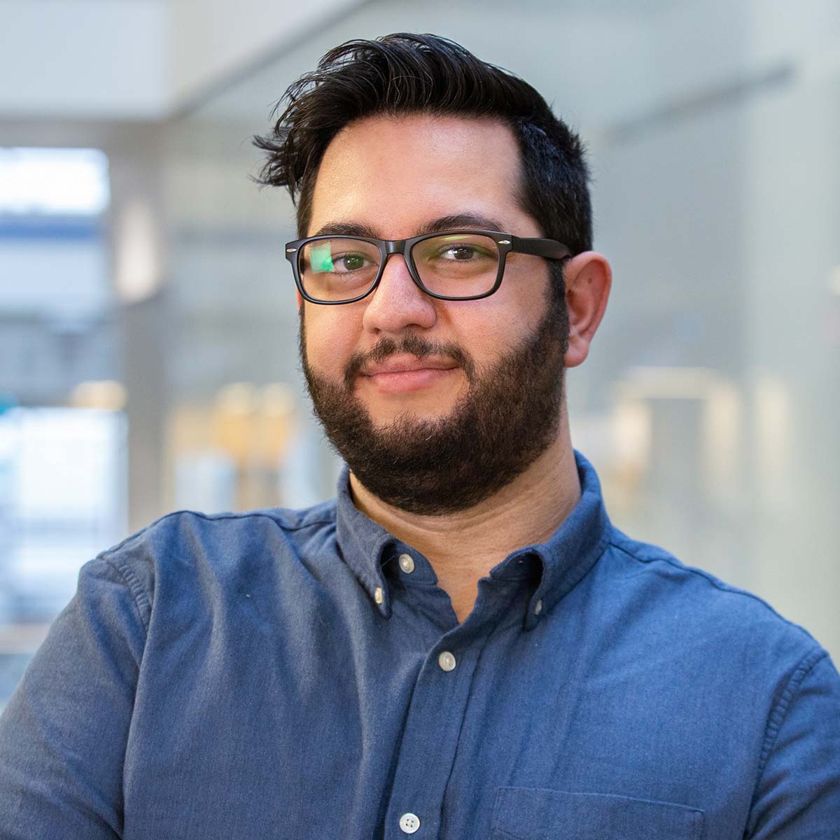 A portrait image of me. I am wearing glasses and a blue shirt.